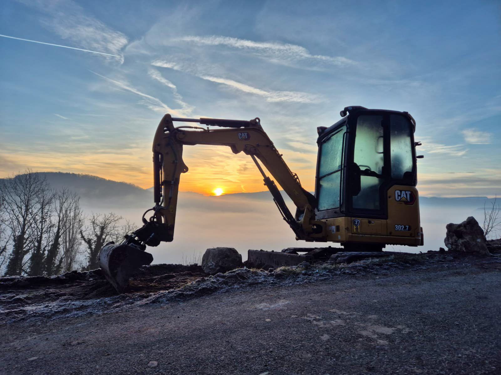 Mini-pelle sur chantier au lever du jour